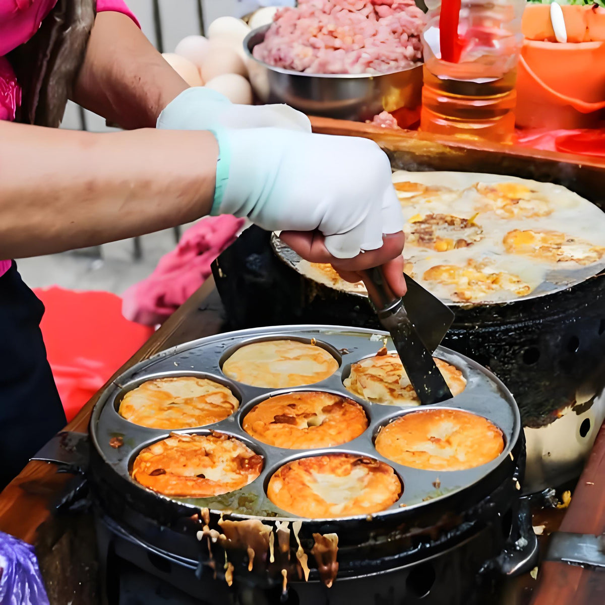 A street vendor preparing traditional Chinese snacks on a hot griddle